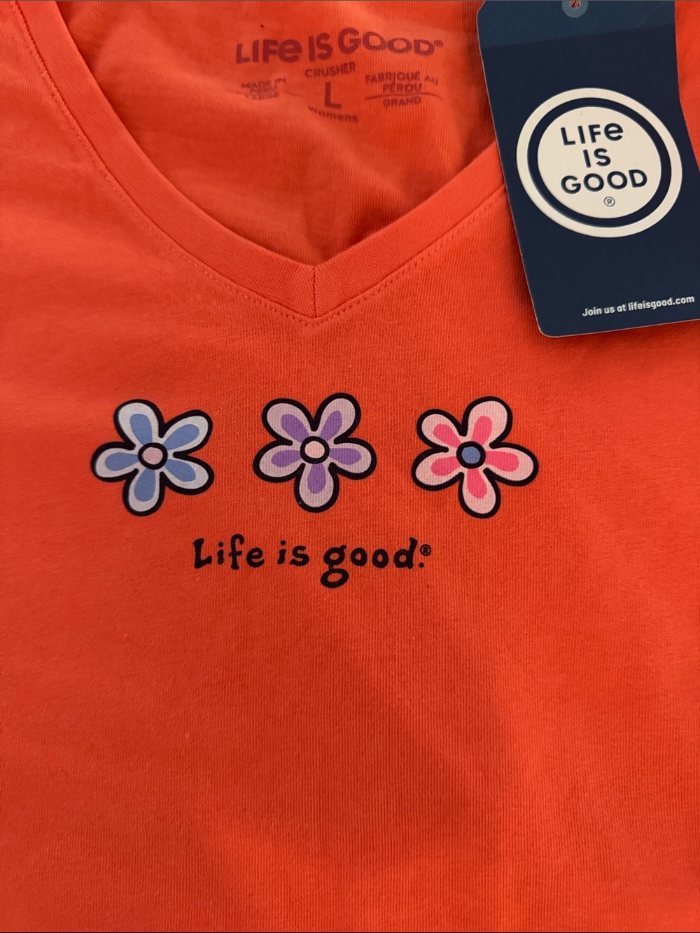Life Is Good Women’s Orange V-Neck Tee with Trio Flower Graphic. NWT
